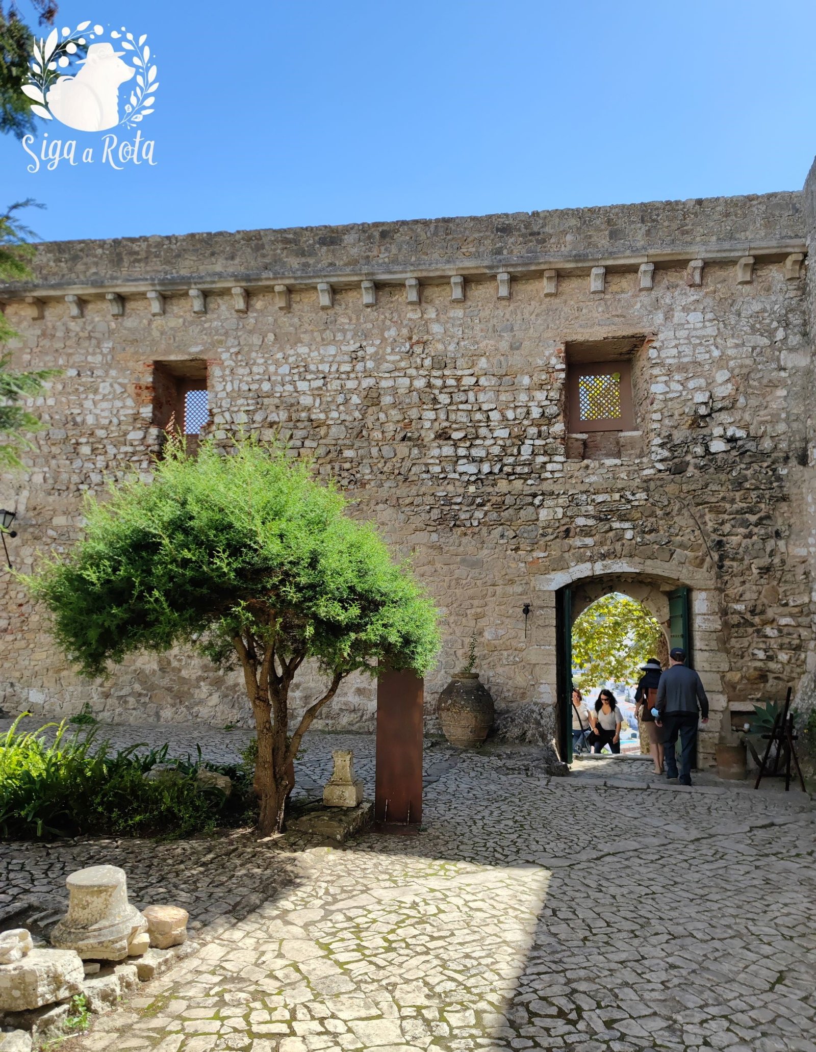 Vista panorâmica do Castelo de Óbidos, um marco histórico e turístico da vila, cercado por muralhas medievais.