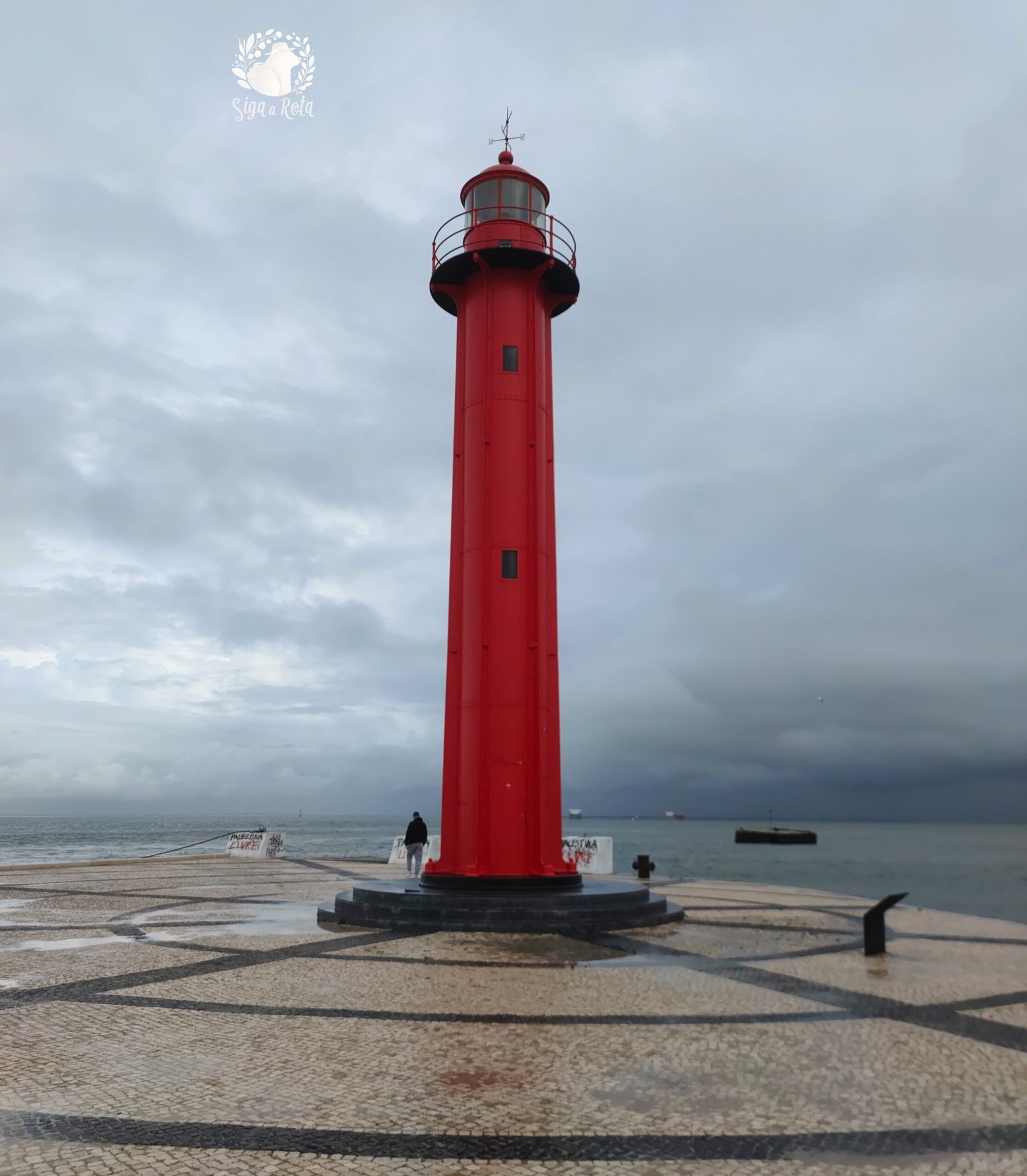 Farol em Cacilhas, Almada, próximo à Fragata D. Fernando II e Glória, um marco na área portuária.