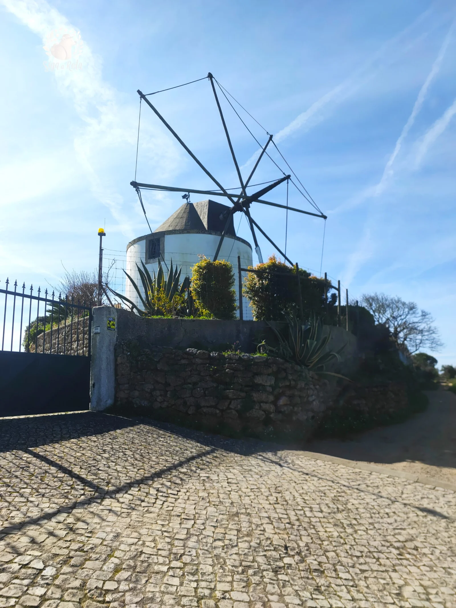 Moinho de vento tradicional ao longo do Trilho dos Moinhos na Serra do Louro, um símbolo da herança cultural da região.