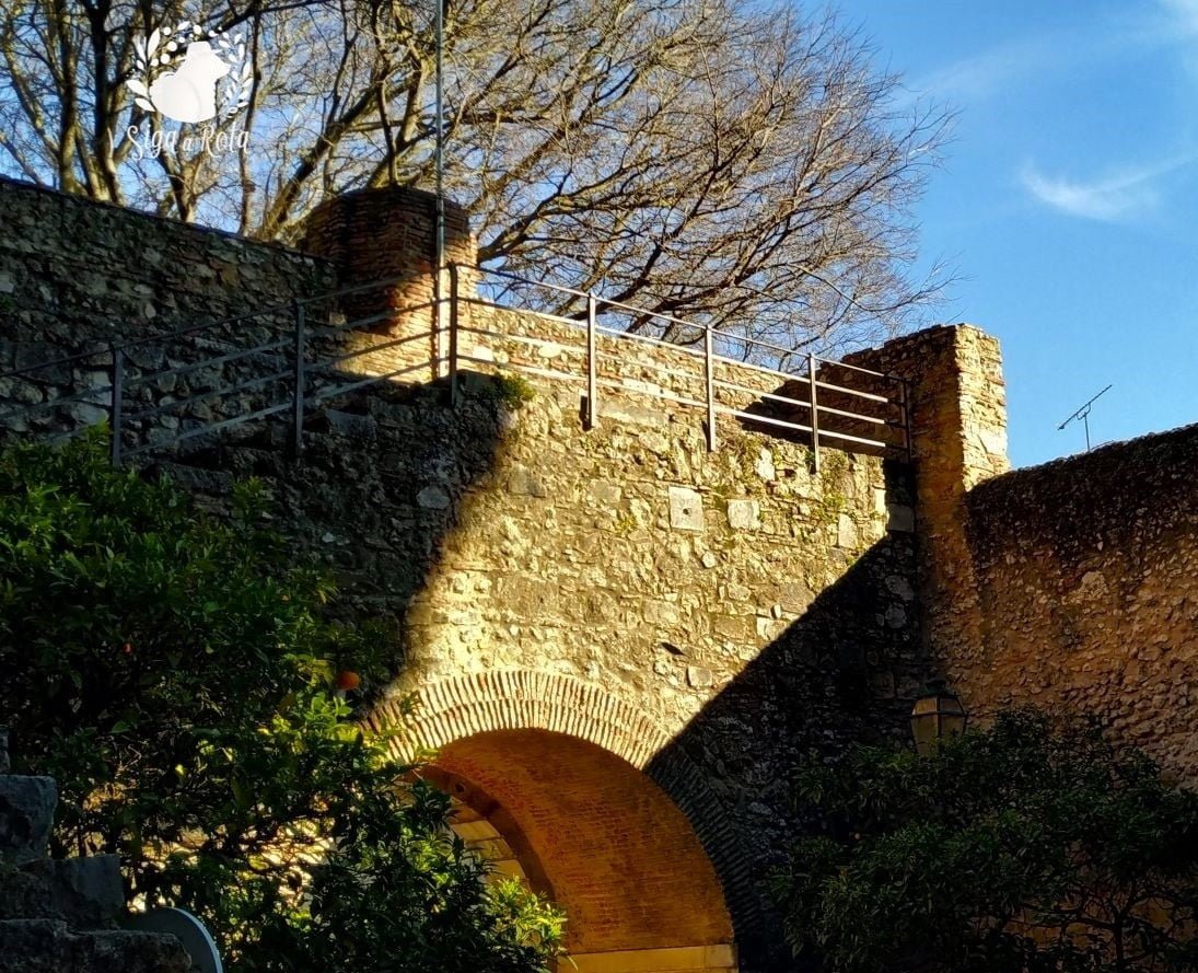 Muralhas históricas do Castelo de São Jorge em Lisboa, Portugal, com vista panorâmica da cidade.