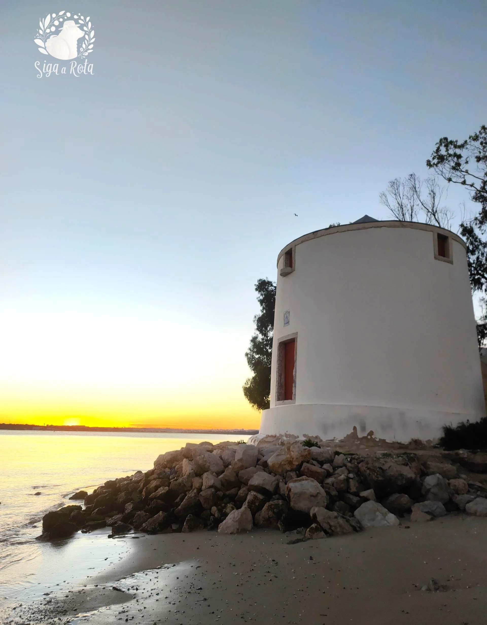 Moinhos de Alburrica com céu alaranjado ao entardecer no Barreiro