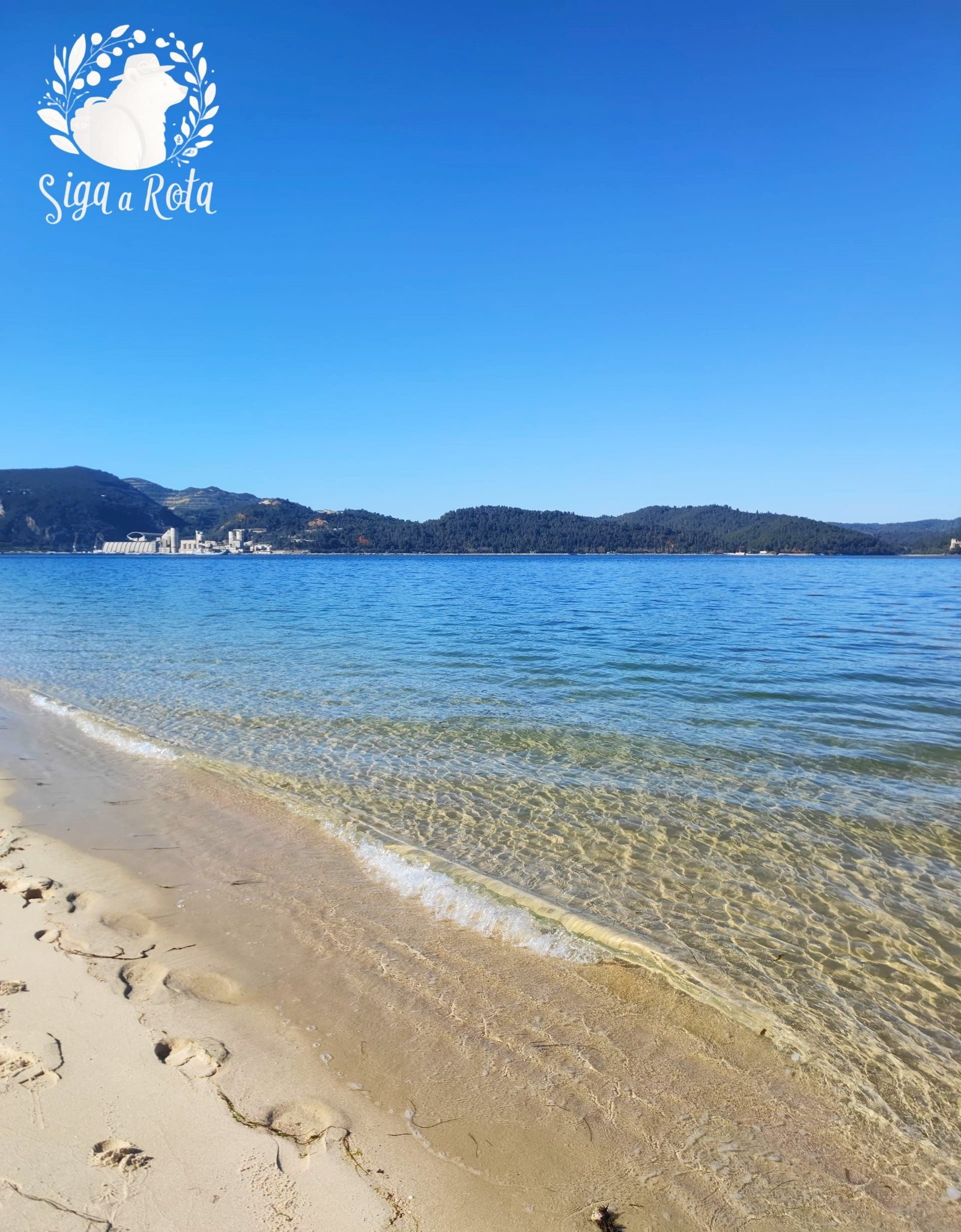 Extensão de areia branca e mar calmo na Praia de Tróia, um cenário perfeito para descansar e aproveitar o sol.