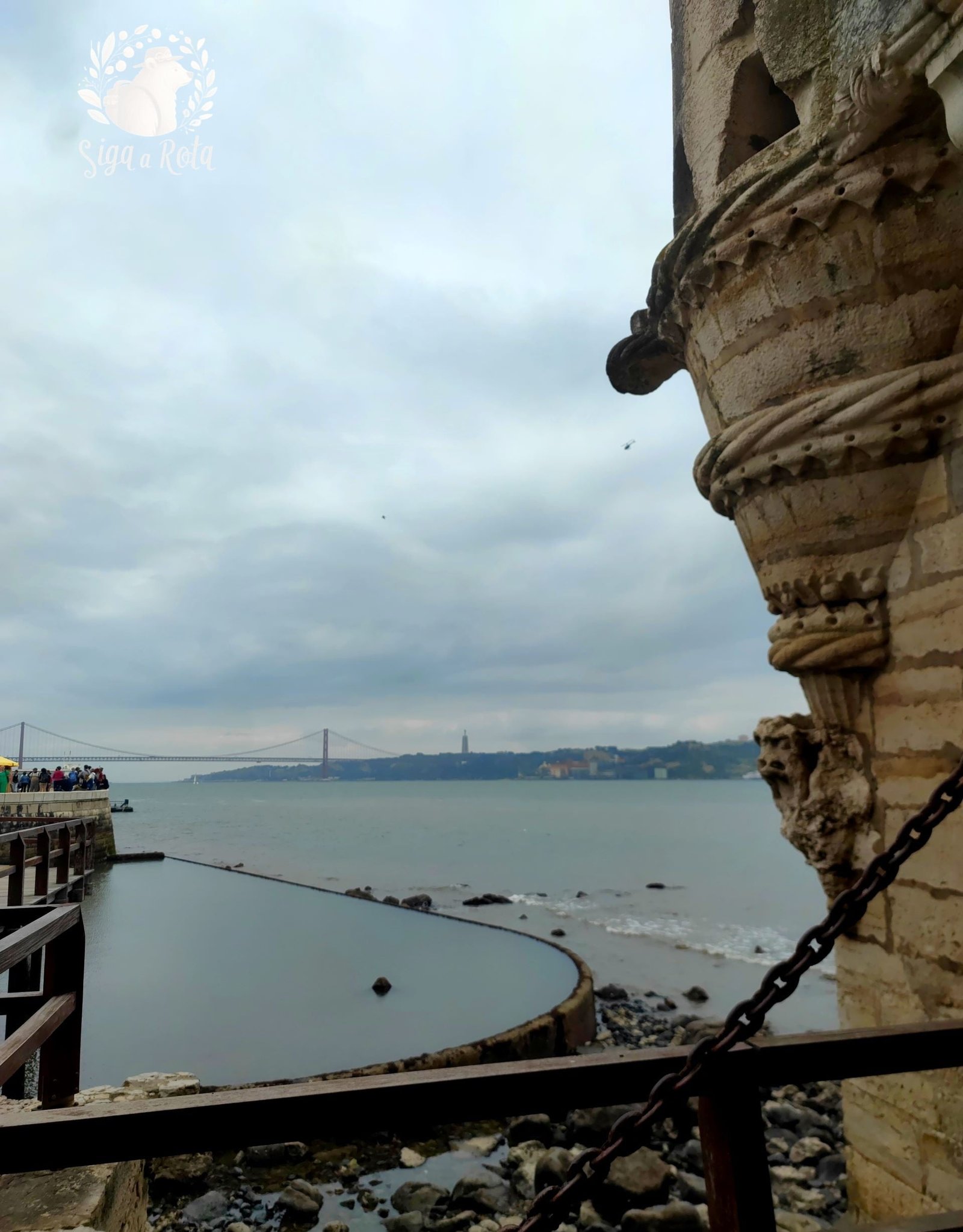 "Vista panorâmica do terraço da Torre de Belém, destacando o Rio Tejo e Lisboa ao fundo.