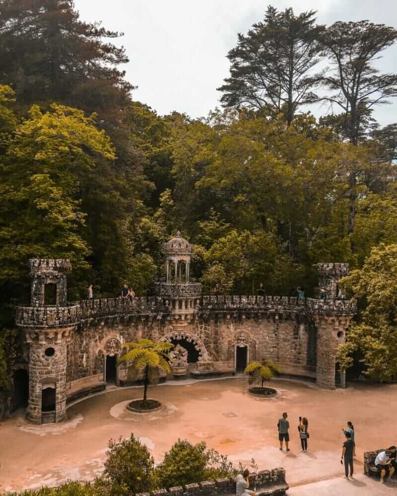 Jardins encantados da Quinta da Regaleira em Sintra, repletos de caminhos sinuosos, grutas e lagos misteriosos que fascinam os visitantes.
