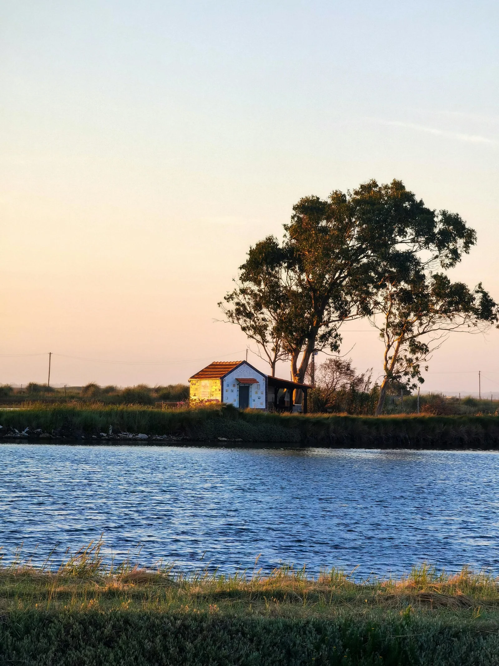 Paisagem das salinas de Aveiro com tanques de evaporação e céu claro.