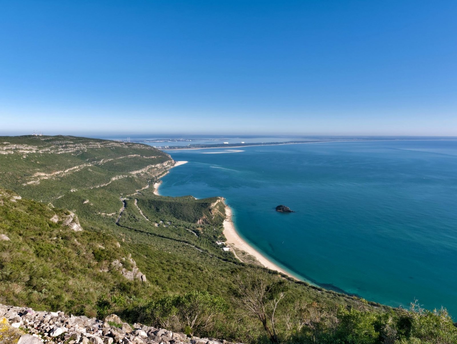 Paisagem verdejante da Serra da Arrábida, com praias isoladas e vistas deslumbrantes do oceano.