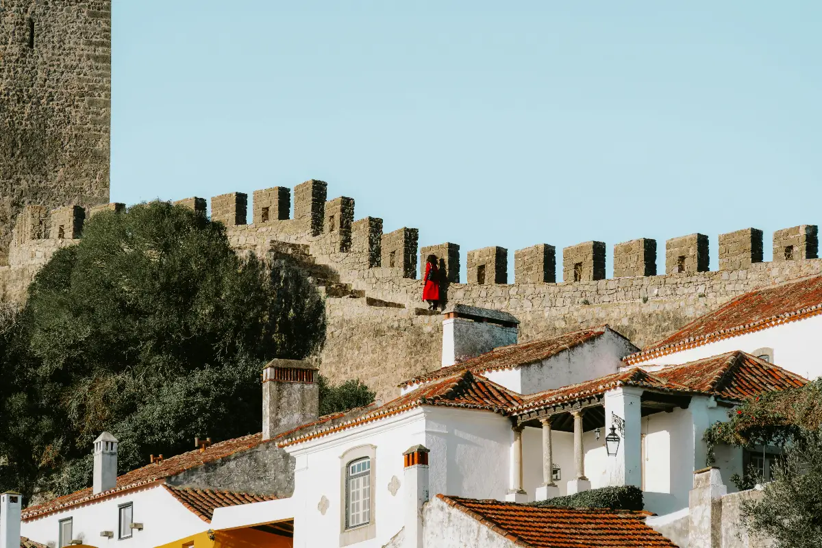 Alt Text: “Castelo e ruas floridas de Óbidos, aldeia fortificada perto de Lisboa, Portugal