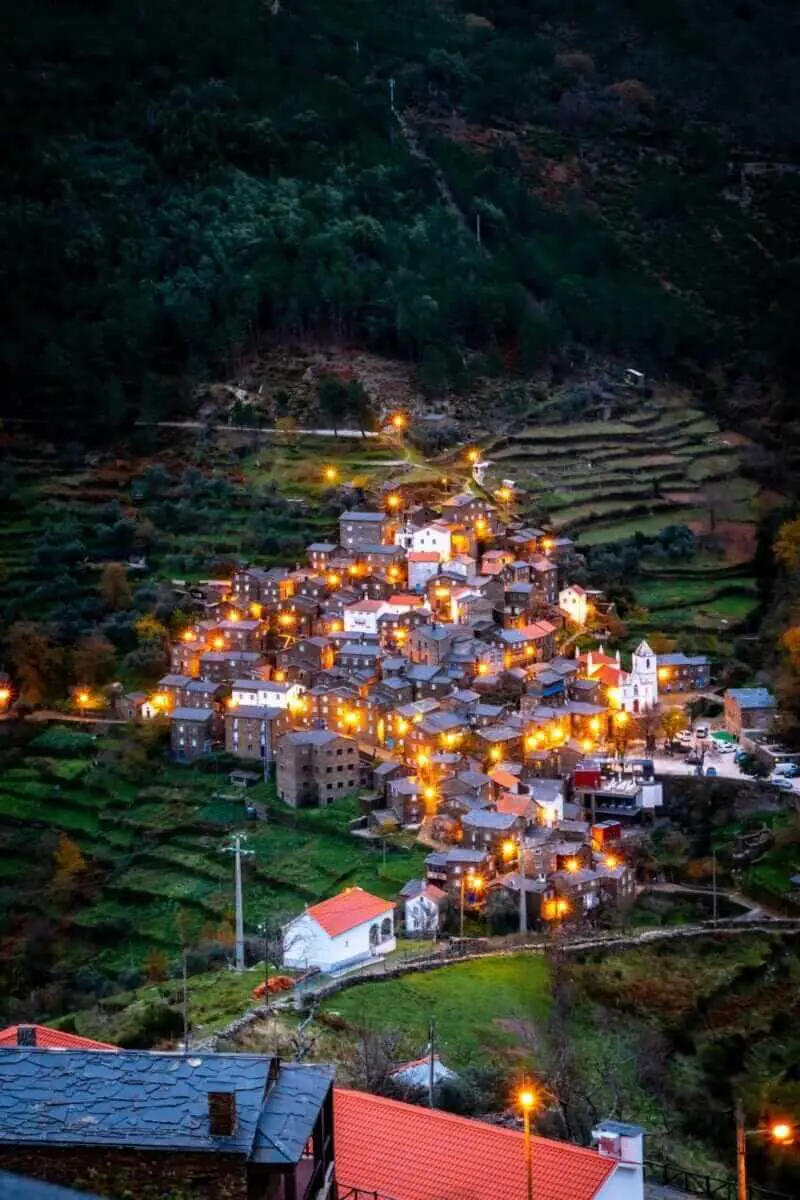 Aldeia de Piódão com casinhas de xisto iluminadas, criando um ambiente mágico para o Natal.
