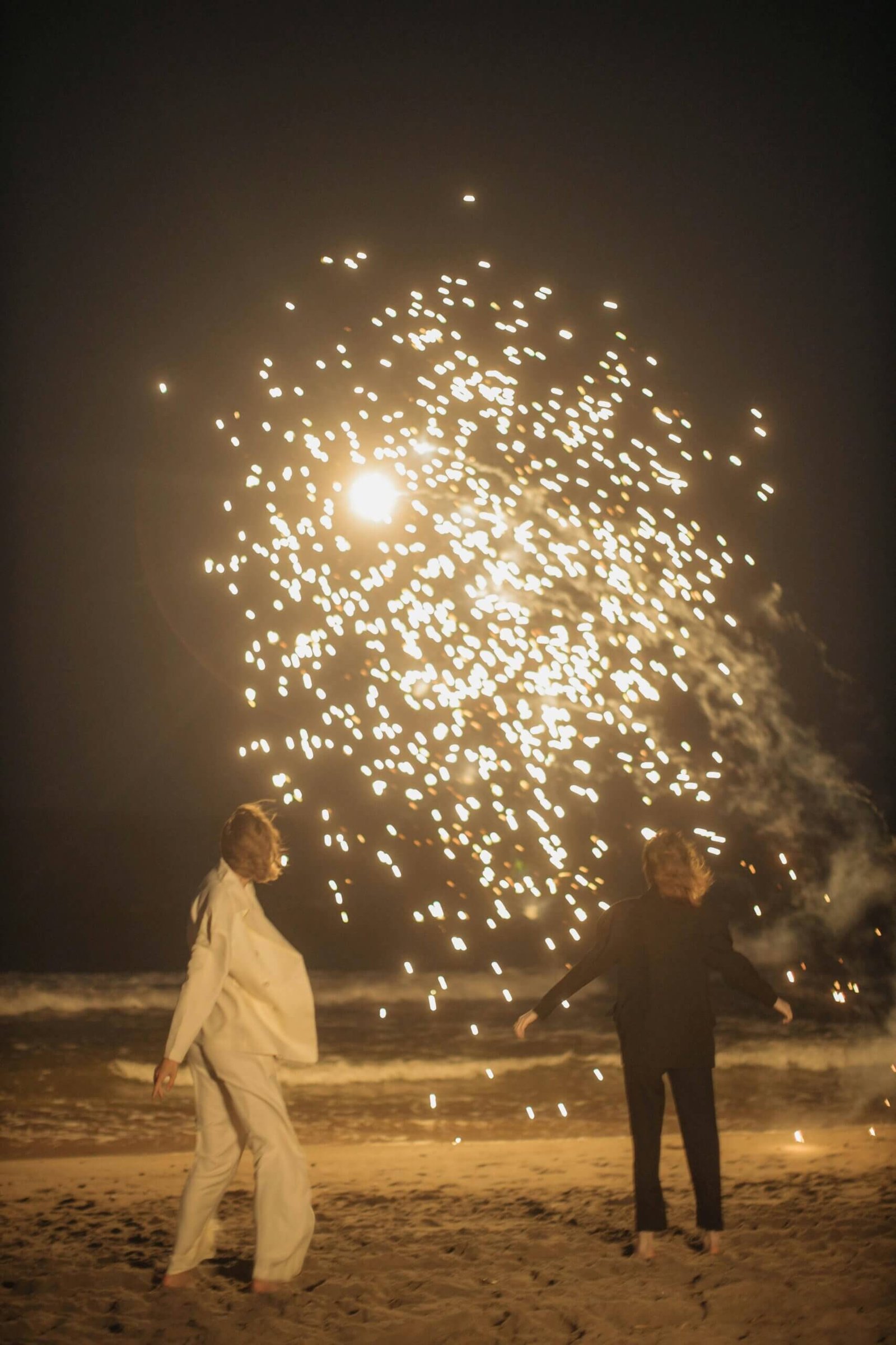 Praia em Portugal ao anoitecer durante as celebrações de Ano Novo, com céu iluminado e ambiente tranquilo.