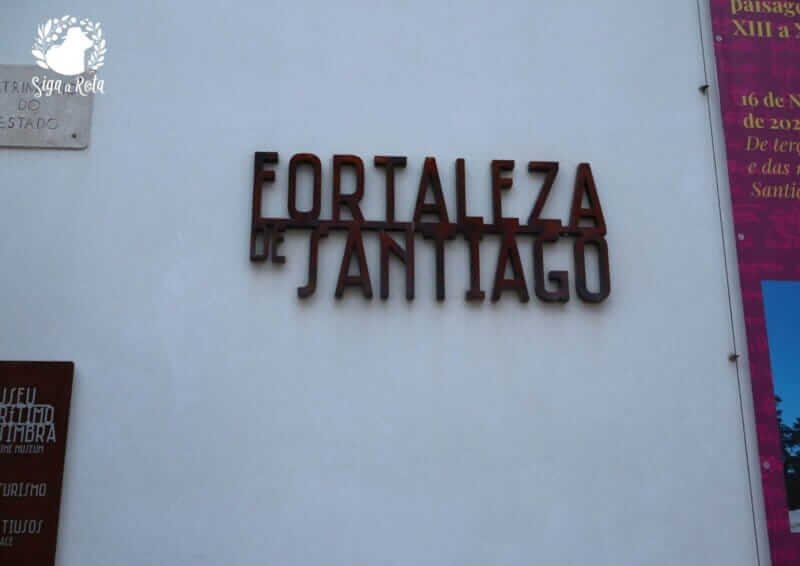 Entrada principal da Fortaleza de Santiago, com arquitetura histórica em frente à Praia do Ouro, em Sesimbra.