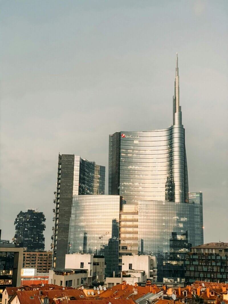 Fachada de vidro da Torre UniCredit refletindo o céu de Milão.