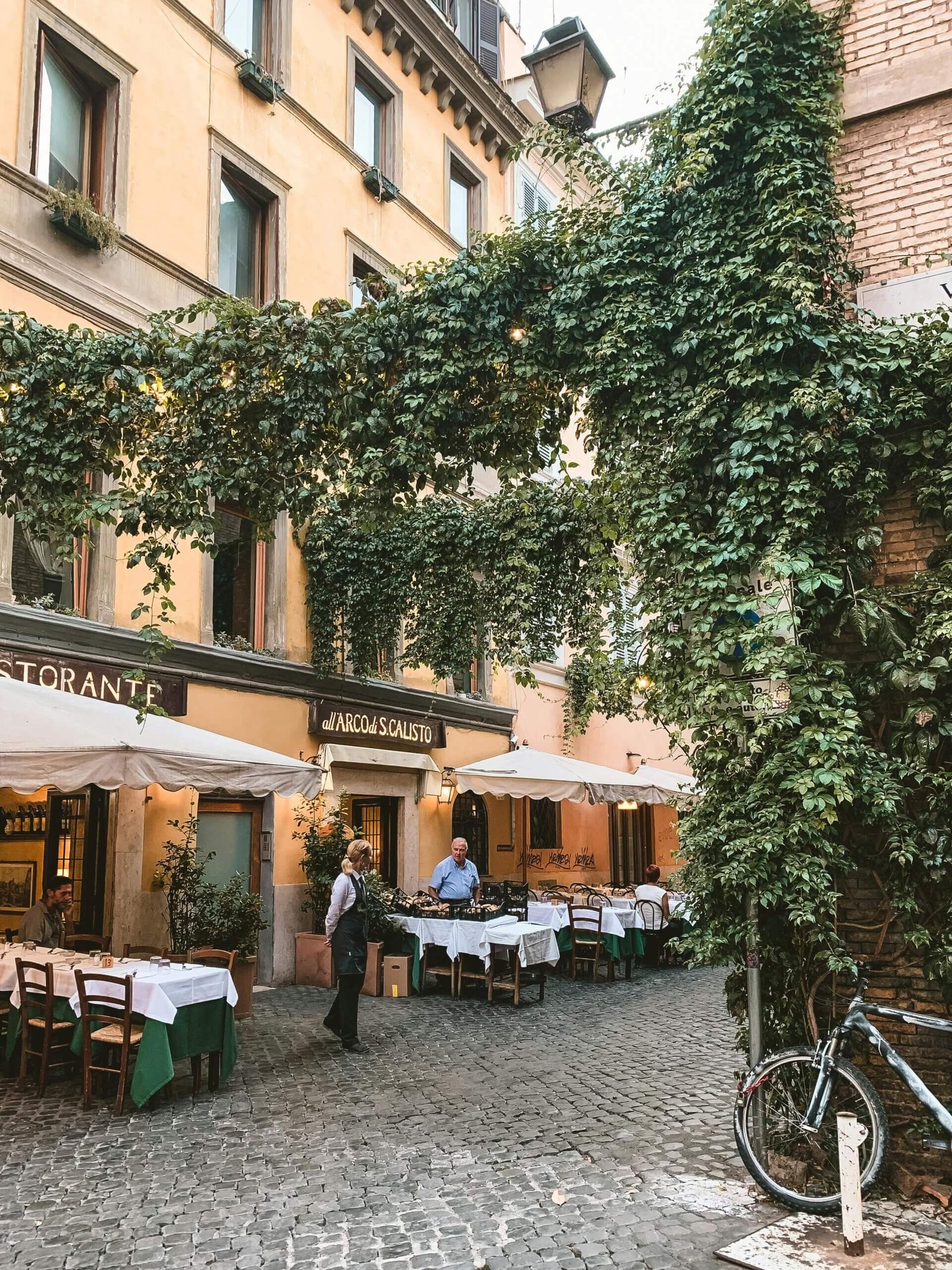 Ruas de paralelepípedos e restaurantes típicos no charmoso bairro de Trastevere, em Roma.