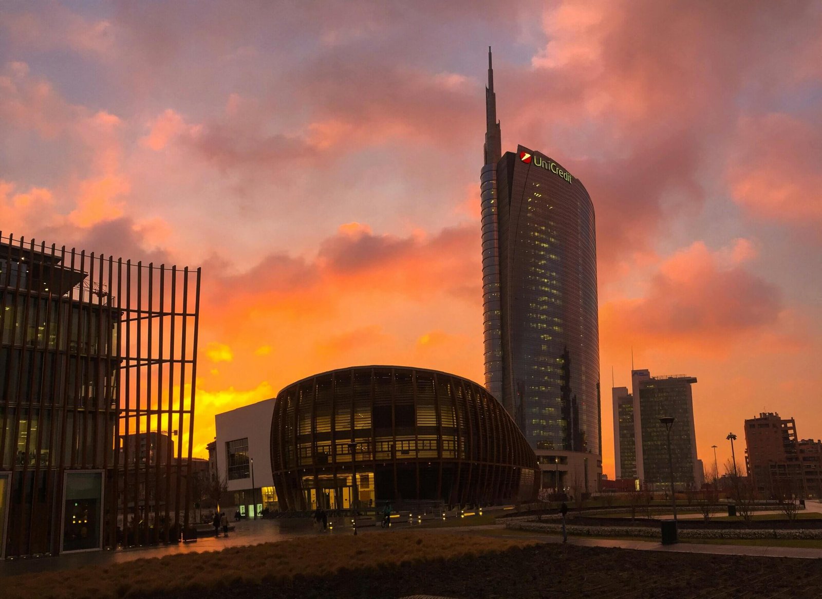 Pessoas sentadas nos bancos da praça, cercadas por arquitetura contemporânea.
