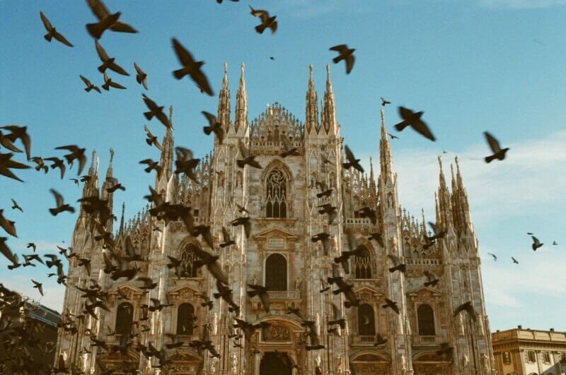 Vista exterior da imponente Catedral de Milão, um ícone da arquitetura gótica na Piazza del Duomo.