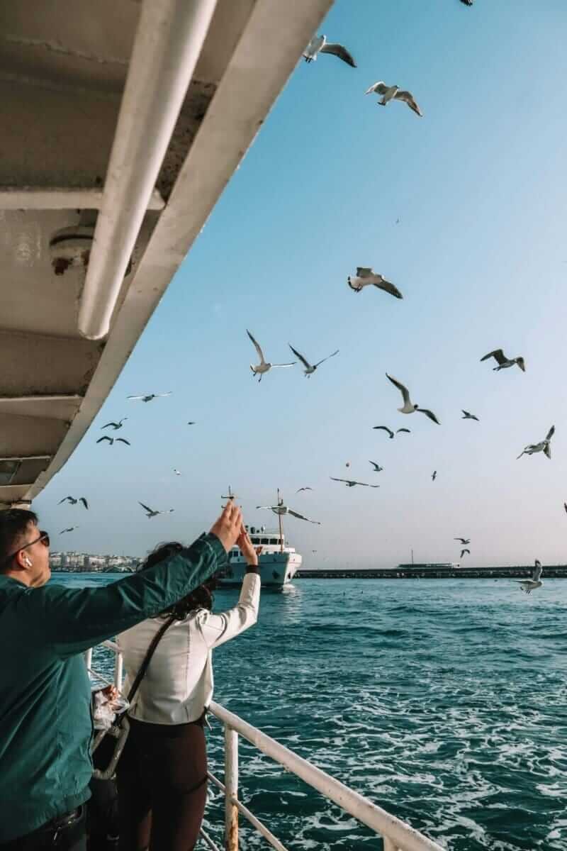 Embarcação navegando pelo Rio Tejo ao entardecer, com Lisboa ao fundo, proporcionando um cenário de puro romance.