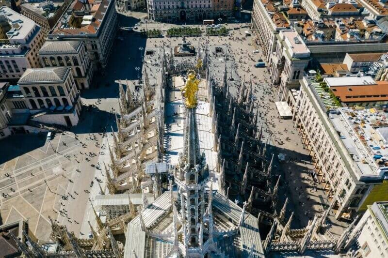 Estátua dourada da Madonnina no topo do Duomo de Milão, um símbolo da cidade.