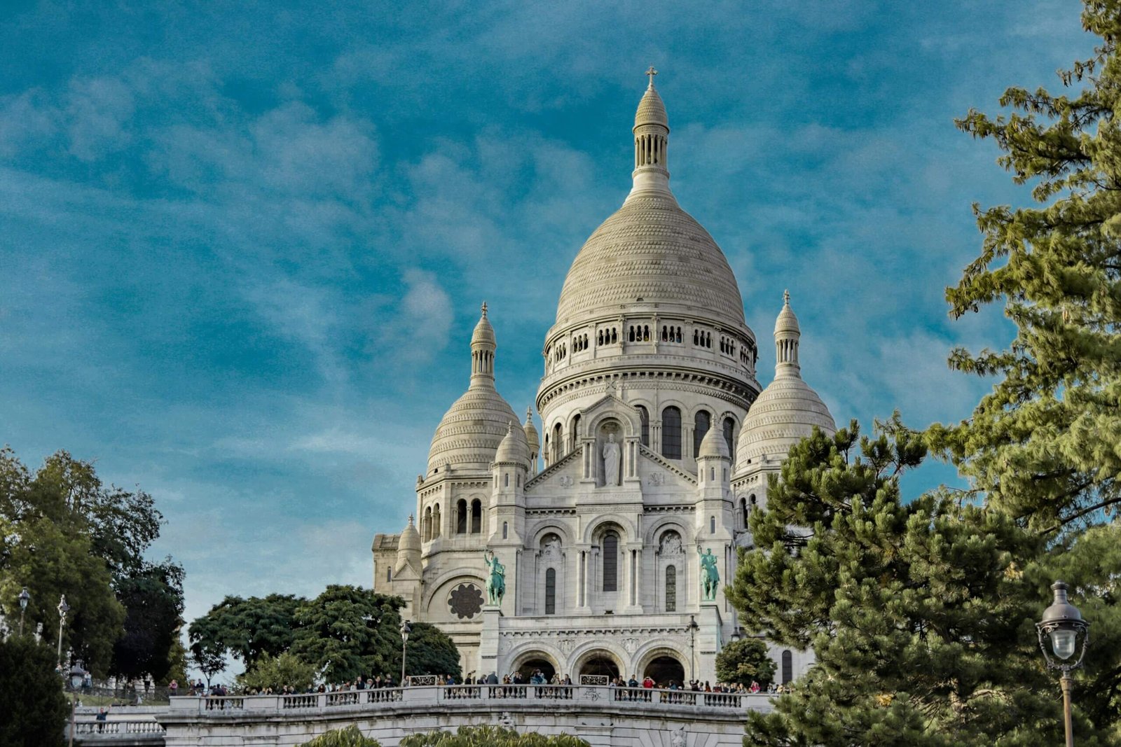 Basílica de Sacré-Coeur no topo de Montmartre, cercada por turistas.